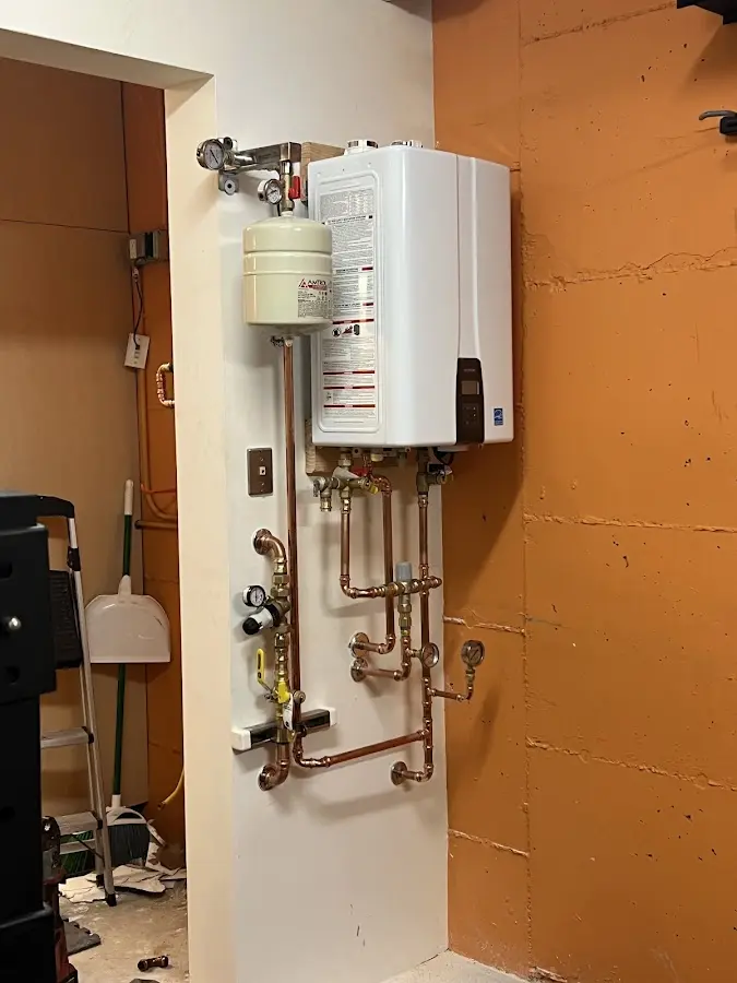 Plumbing technician inspecting water heater connections in Mount Olive